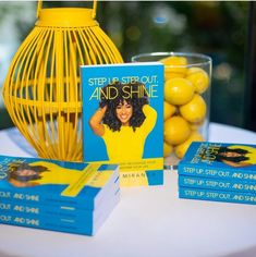 a table topped with books and lemons next to a yellow cage filled with lemons