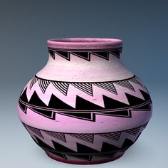 a pink and black vase sitting on top of a table