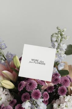 a bouquet of flowers with a note that says more than just flowers