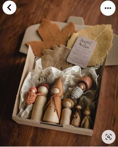 an open box filled with wooden shoes on top of a wooden table next to leaves