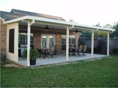 a covered patio with table and chairs on it