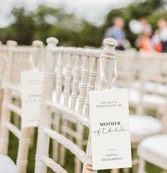 the chairs are lined up with signs on them for guests to sit down and read