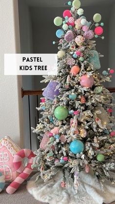 a white christmas tree decorated with pastel ornaments