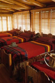 there are many beds in the room with plaid blankets