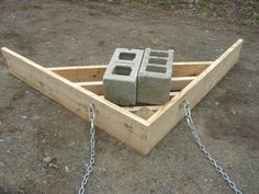 a wooden box with chains attached to it and some concrete blocks in the back ground