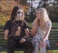 two people sitting on a bench eating ice cream