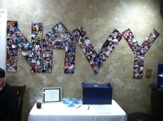 a man sitting at a table in front of a wall with many pictures on it