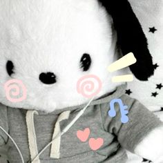 a white stuffed animal with black ears wearing a gray hoodie and hearts on it's chest