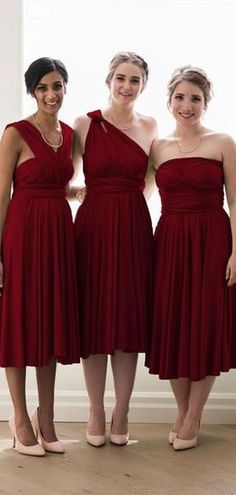 three women in red dresses standing next to each other