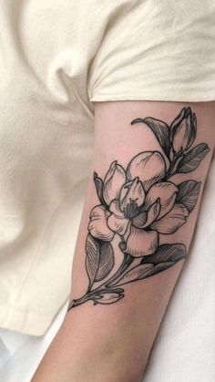 a black and white flower tattoo on the arm