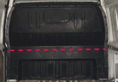 the back end of a van with its cargo door open and red lines on it