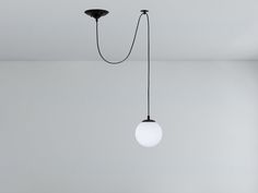 a white light hanging from the ceiling in a room with gray walls and flooring