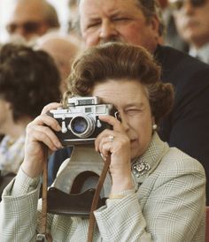 a woman taking a photo with an old camera