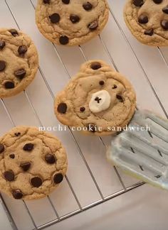 chocolate chip cookies with a white teddy bear in the middle are cooling on a rack