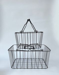 Vintage Wire Gathering Baskets Square Handled Large Thick S/2 High Quality Description Vintage Large Thick Wire Square Handled  Gathering Baskets High Quality Set of 2 _____________ Hit’s Quality Vintage Wire frame baskets can hold it’s own atop a large tabletop or hugging a grouping as a floor basket. The handles have coiled heavy duty grips, looped connected, moves freely. Black Patina and Geometric Square Wire Pattern would easily lend itself to a “Modern Farmhouse” or “Industrial” or “Industrial Farmhouse” interior ______ Large Basket: Approximately 9”x17”x19” Small Basket Approximately 7.5”x13”x11” STYLES: Industrial, Farmhouse, Modern Farmhouse, Gathering ORIGINAL CONDITION: Original Condition Unaltered PERIOD:1990s ITEM TYPE: Vintage, Pre-owned MATERIALS: Metal COLOR: Black Patina T Industrial Farmhouse Interior, Baskets Square, Floor Basket, Floor Baskets, Large Basket, Small Basket, Farmhouse Modern, Wire Basket, Farmhouse Interior