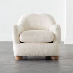 a white chair sitting on top of a hard wood floor next to a gray wall