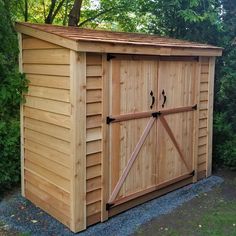 a wooden storage shed with the door open and two sliding doors on it's side