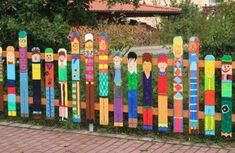 a fence made out of legos and painted to look like people in different colors