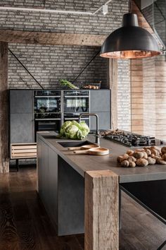 an industrial style kitchen with wood floors and brick walls