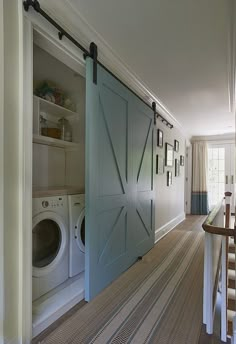 an open door in the middle of a hallway next to a washer and dryer