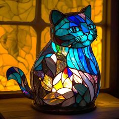 a stained glass cat sitting in front of a window