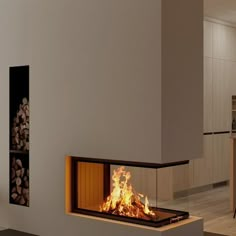 a fire place in the middle of a room with wood stacked on it's sides