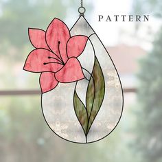 a stained glass flower hanging from a window with the words pattern on it and an image of a pink flower