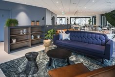 a living room filled with furniture and lots of plants on top of the tables in front of them