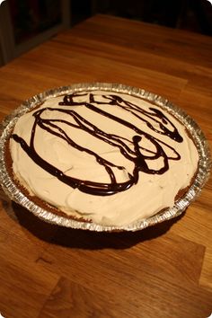 a cake sitting on top of a wooden table covered in frosting and icing