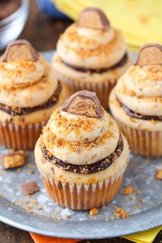 several cupcakes with frosting and sprinkles sitting on a plate