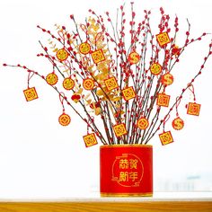 a red vase filled with branches and decorations