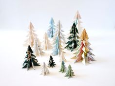 small paper christmas trees on a white surface