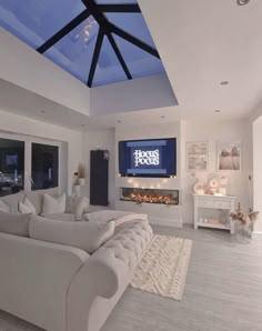 a large living room with white furniture and a skylight