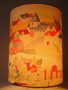 a lampshade with an image of houses painted on it