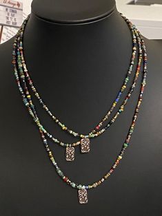 the necklace is decorated with multicolored beads and two pendants on each strand