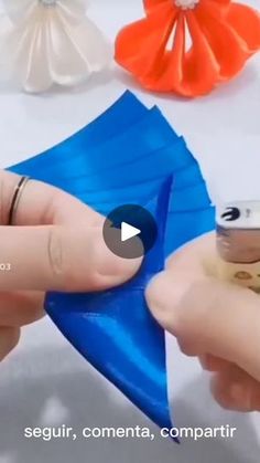 two hands are holding an origami airplane and another hand is placing it on top of the other