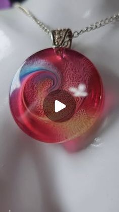 a necklace with a red glass disc on it