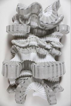 an art piece made out of knits and paper on a white surface with one folded in the middle