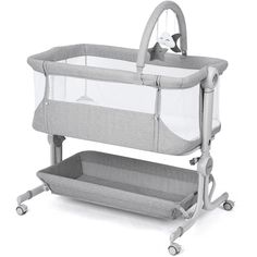 a baby crib that is on top of a white surface with wheels and handles