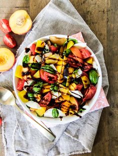 a bowl filled with lots of different types of food on top of a wooden table