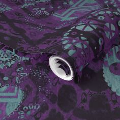 a purple and teal wallpaper with skulls on it, as well as an intricate design