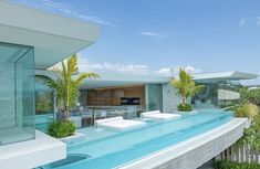 an outdoor swimming pool with lounge chairs and palm trees