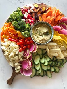 a platter filled with vegetables and dip