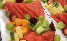 slices of watermelon, grapes, kiwi, and strawberries on a white plate