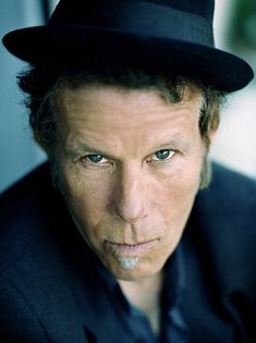 a close up of a person wearing a hat and looking at the camera with a serious look on his face