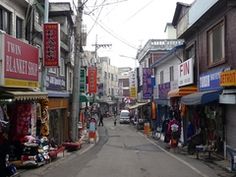 an empty street with shops and people walking down it