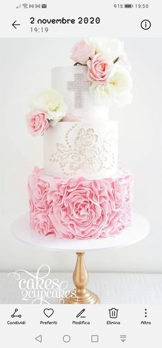 a three tiered cake with pink and white flowers on top is decorated with a cross