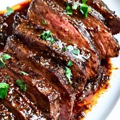 steak with sauce and parsley on a white plate