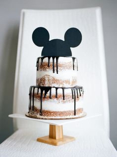 a mickey mouse cake with icing and chocolate drizzles on it's top