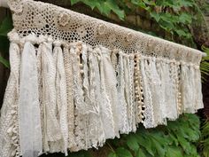 an old lace curtain hanging from a tree